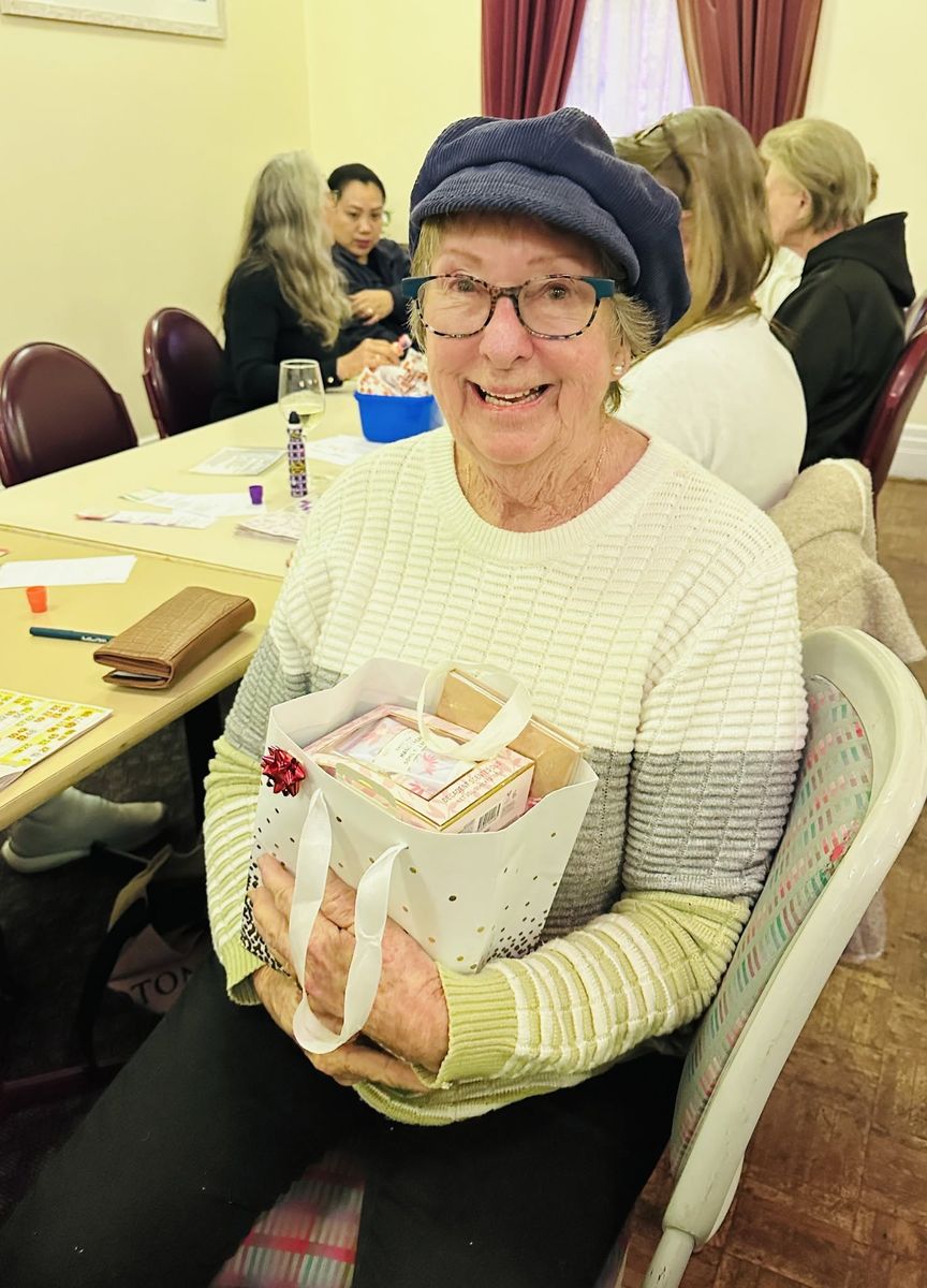 A delighted woman holding a gift bag prize