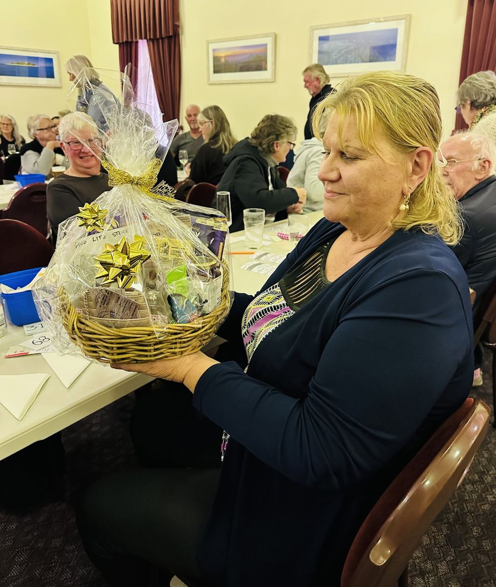 A woman holding up a prize hamper